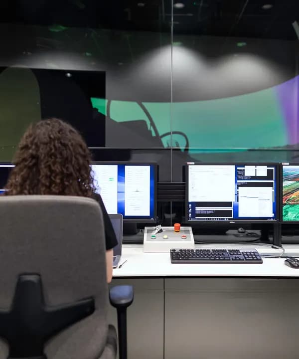 An operator at a desk of monitors, seen from behind