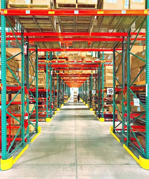 A warehouse aisle lined with racked pallets